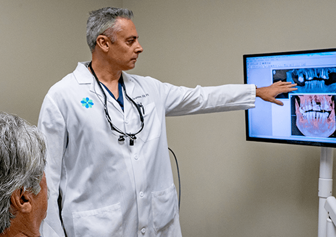 Dr. E explaining dental imaging to a seated patient